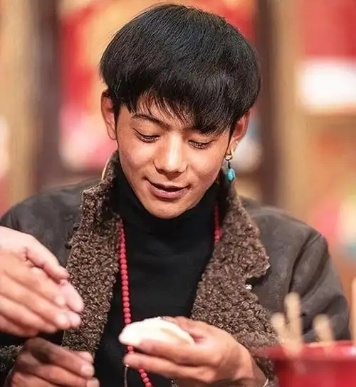 藏袍色彩斑斓,皮肤晒得健康黝黑,脸庞线条硬朗,笑容羞涩又纯净,眼睛