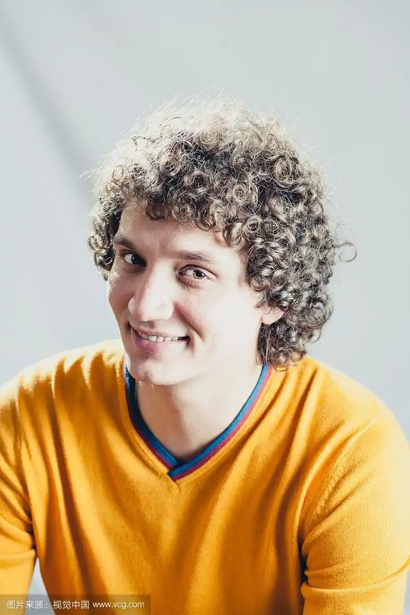 画室里一个卷发的白人男子的垂直图像