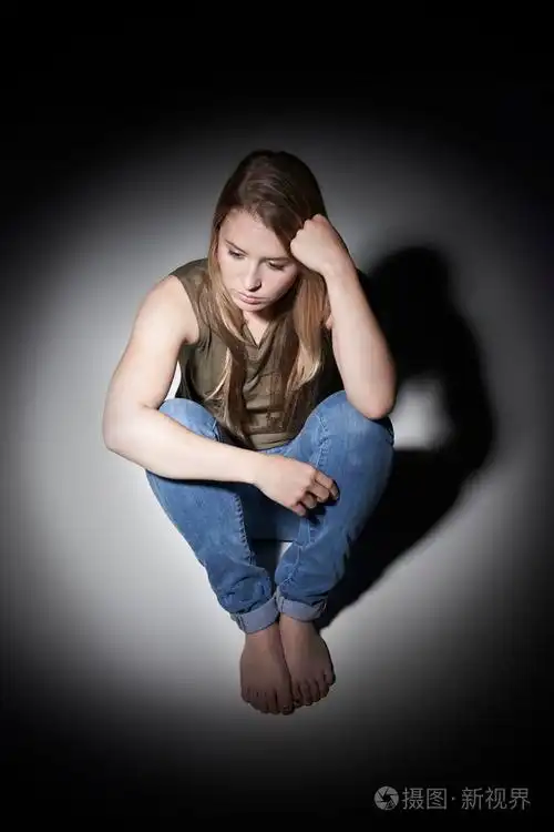 不快乐的年轻女人坐在池的光