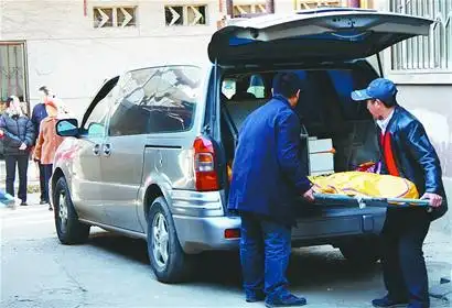 死者被殡仪馆的工作人员抬上车拉走. 记者崔健 实习生卜秀姣 摄