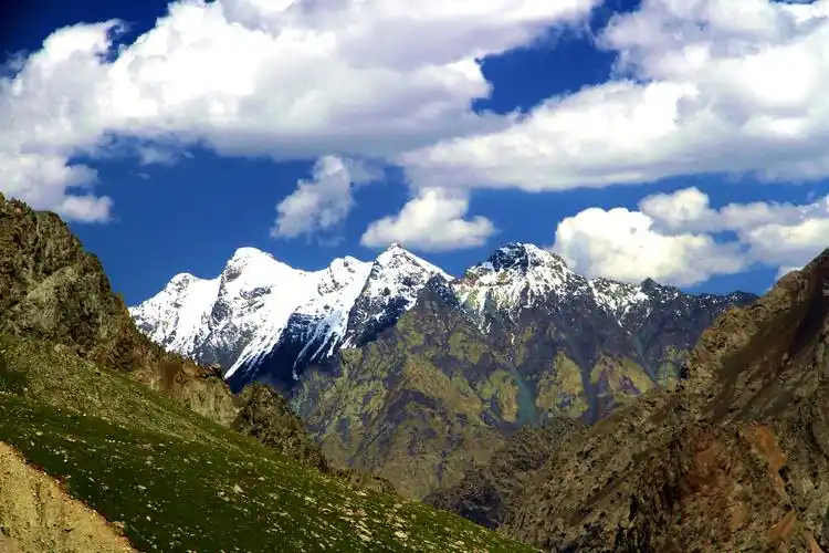 蓝天白云下的嶙峋雪山.