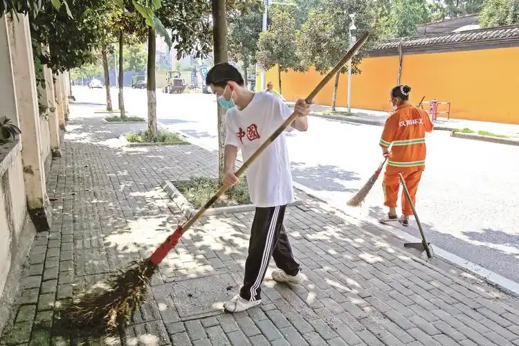 大学新生拿起扫帚帮妈妈扫马路 感受环卫工的不易是他的"开学第一课"