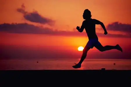 健壮的男人,在橘红色的日出,男性慢跑与肌肉发达的身体,在行动中,运行