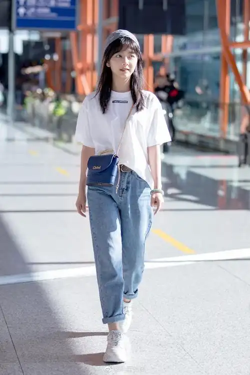 8月27日,谭松韵现身北京机场,burberry白t搭配卷边牛仔裤