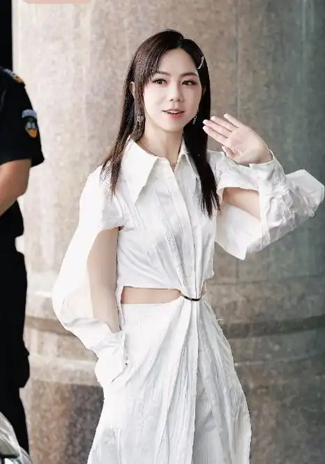 邓紫棋外面搭配了一件镂空风格的衬衣裙,能够让她秀出纤细的腰部线条