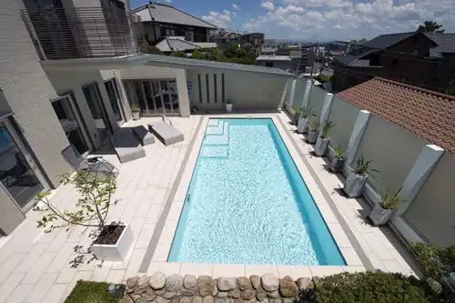 蓝天白云下灰色装修风格的豪宅里的游泳池