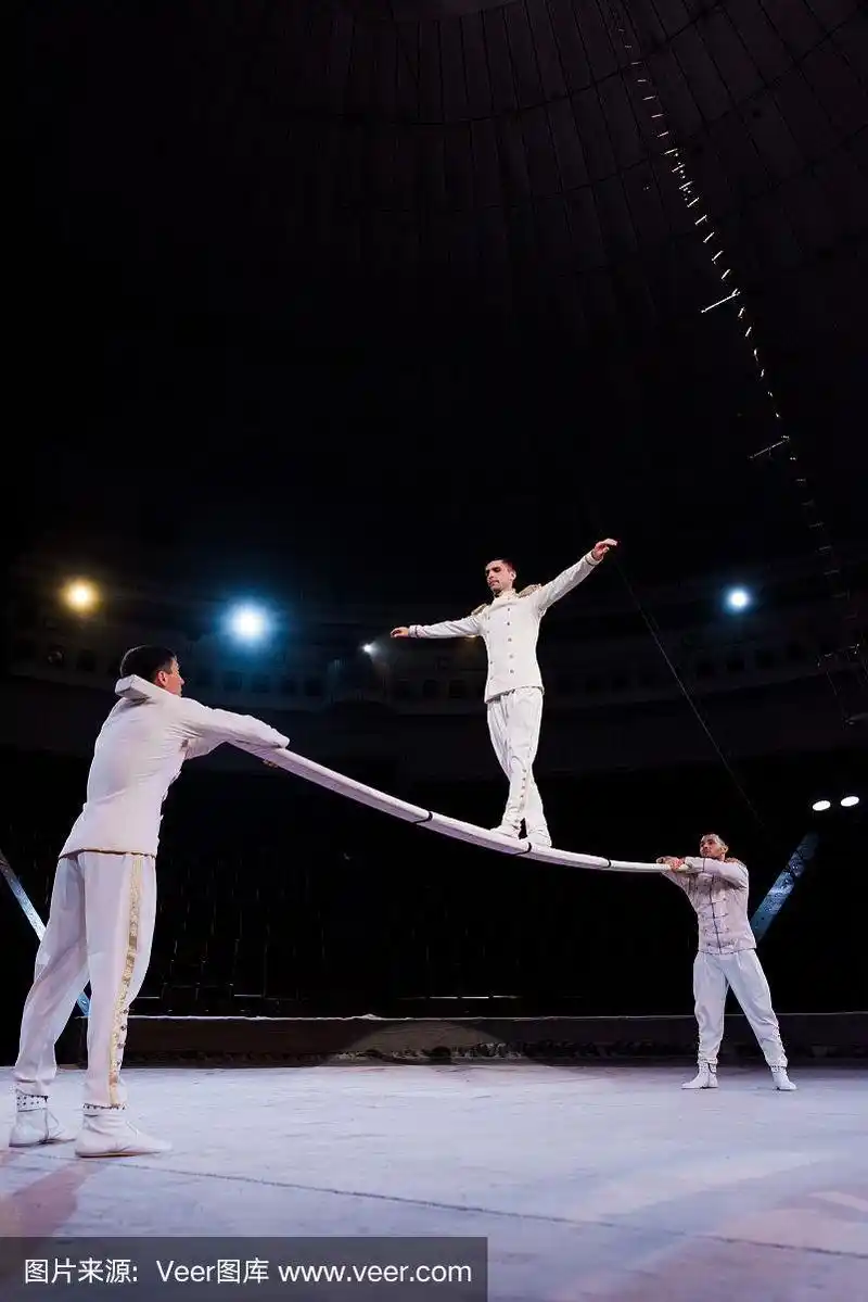 杂技演员在马戏团用手支撑人在金属杆上行走