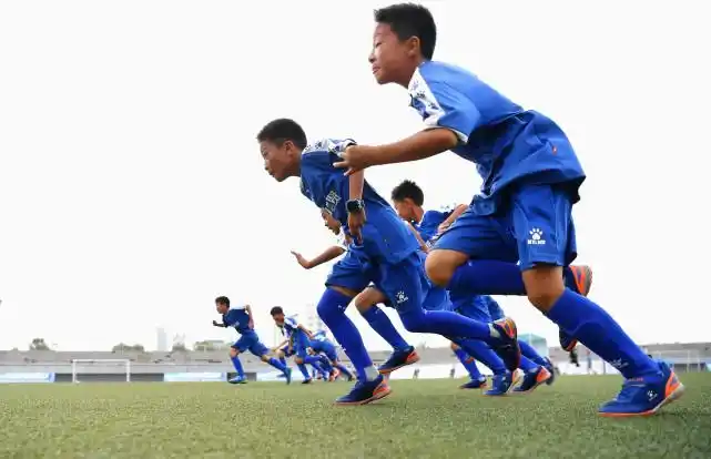 唐山海港经济开发区的城区小学的小球员们在进行体能训练.