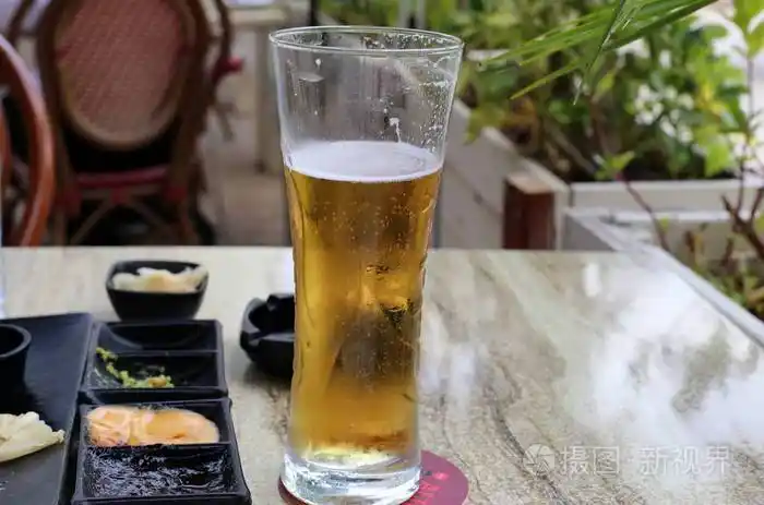 在桌子上的一家餐馆里喝着一杯冰镇啤酒照片-正版商用图片17ysi2-摄图