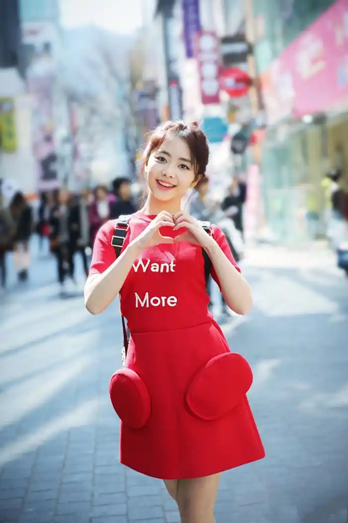 谭松韵穿一件大红色裙子,扎着丸子头,比心的姿势很是可爱,你觉得自己