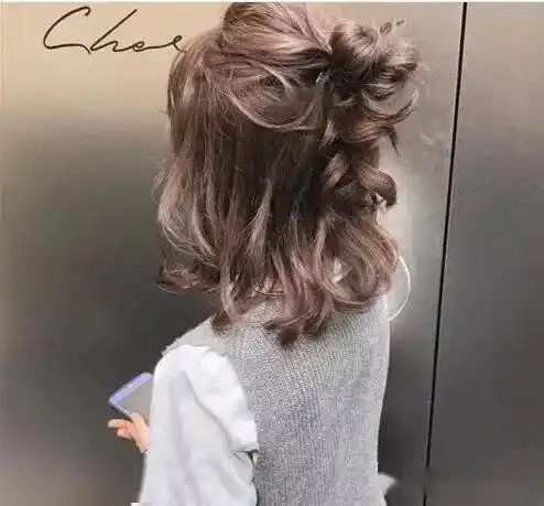 齐肩式的女生的半扎丸子头发型,她的头发很卷,扎出来的丸子头发型也有