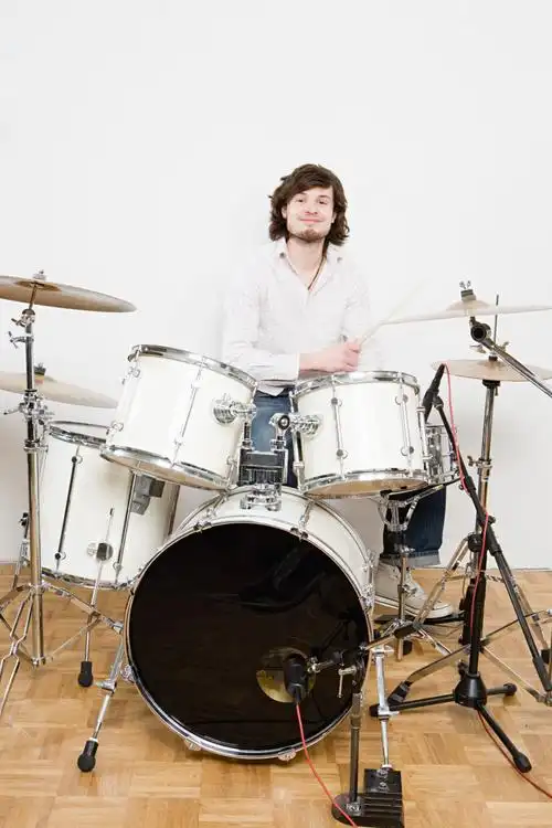 女人将手搭在打架子鼓的男人肩上