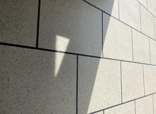 浅色真石漆搭配装饰线,观感不错,连廊内侧部分为深色涂料,立面造型上