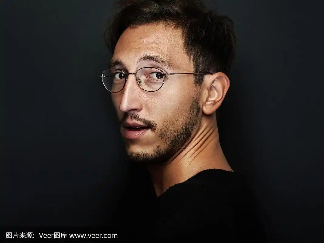 可爱的男人戴着眼镜回头看的肖像.水平