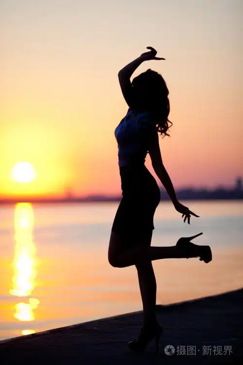 在日出的完美身材的性感女人的剪影