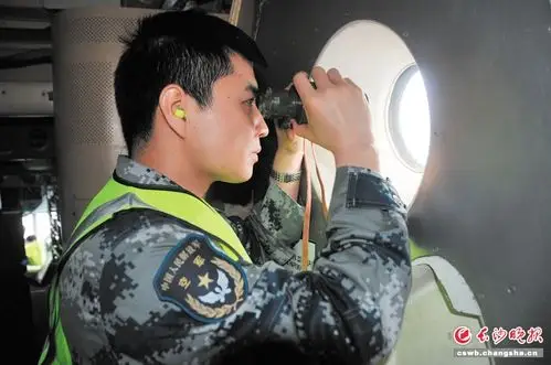 中国空军飞机观察员通过飞机货舱的观察窗观察海面