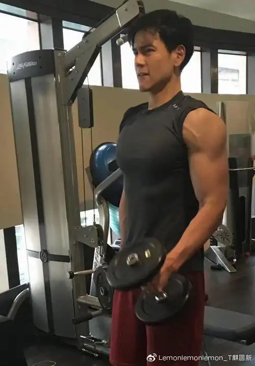 身穿灰色健身t恤的彭于晏将袖子卷起制造成工装背心的造型,大方展示