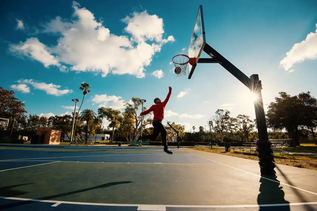 夏天的午后,阳光灿烂,翠绿的草地上,一群年轻人在打篮球.球场上充满着