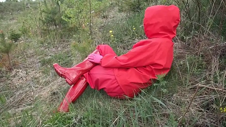 穿红色雨衣红色高筒hunter雨靴侧卧草丛中