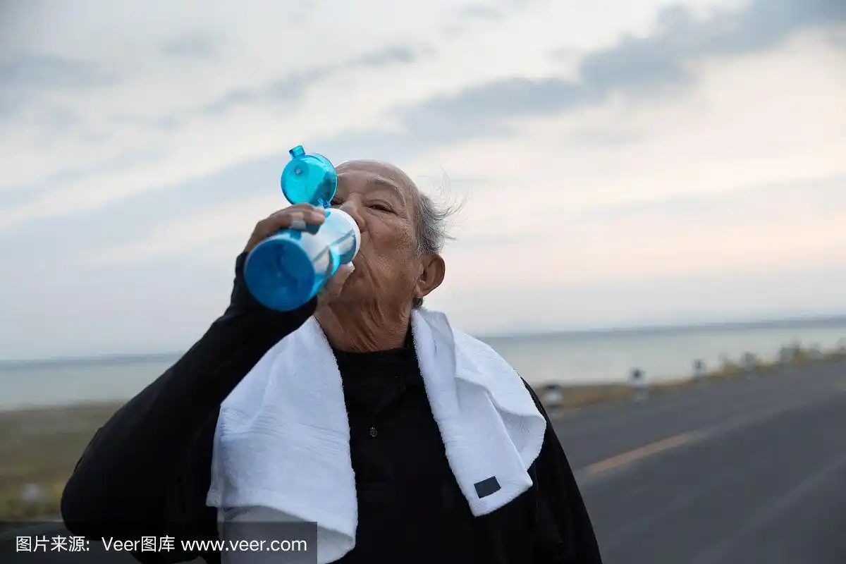 亚洲老年人早上锻炼后喝水.健康的生活方式和锻炼的概念.