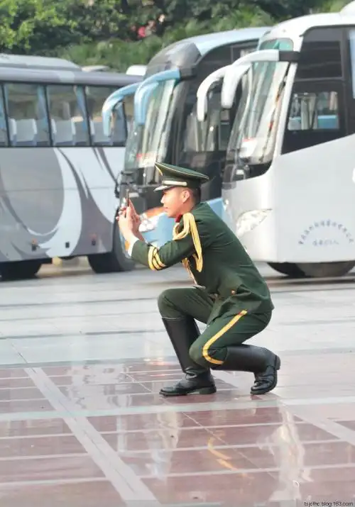 《脚蹬大马靴的帅兵使用手机拍照》