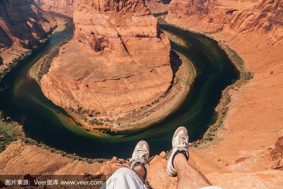 一个年轻人坐在悬崖边上.