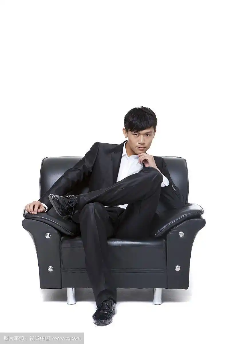 穿着西装的男人坐在沙发上的姿势摄影