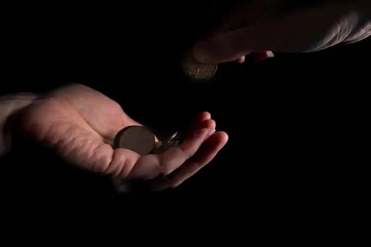 一只手上拿着硬币