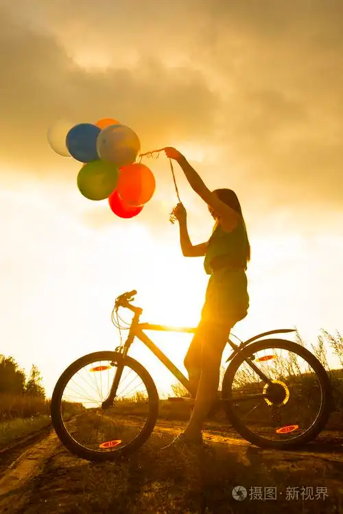 年轻女孩穿着性感的裙子骑自行车飞气球