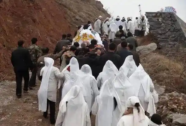 农村出丧时,晚辈手里为何要拿一根白纸糊的棍子,有什么用处?