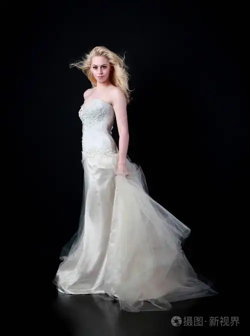 穿白色新娘礼服的模特全长肖像, 黑色背景站立姿势照片-正版商用图片