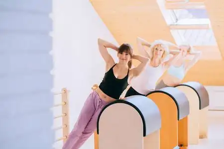 健身教练进行普拉提练习,训练桶内设备.