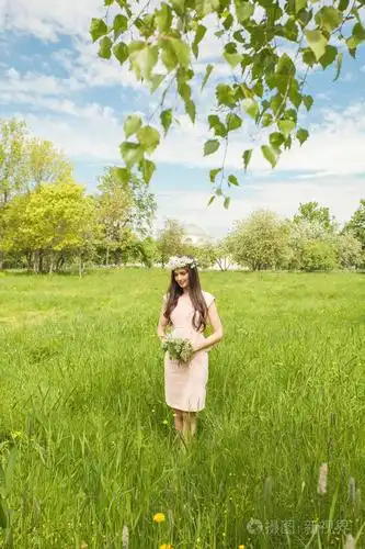 春天公园的年轻女子.绿色草的女孩背景