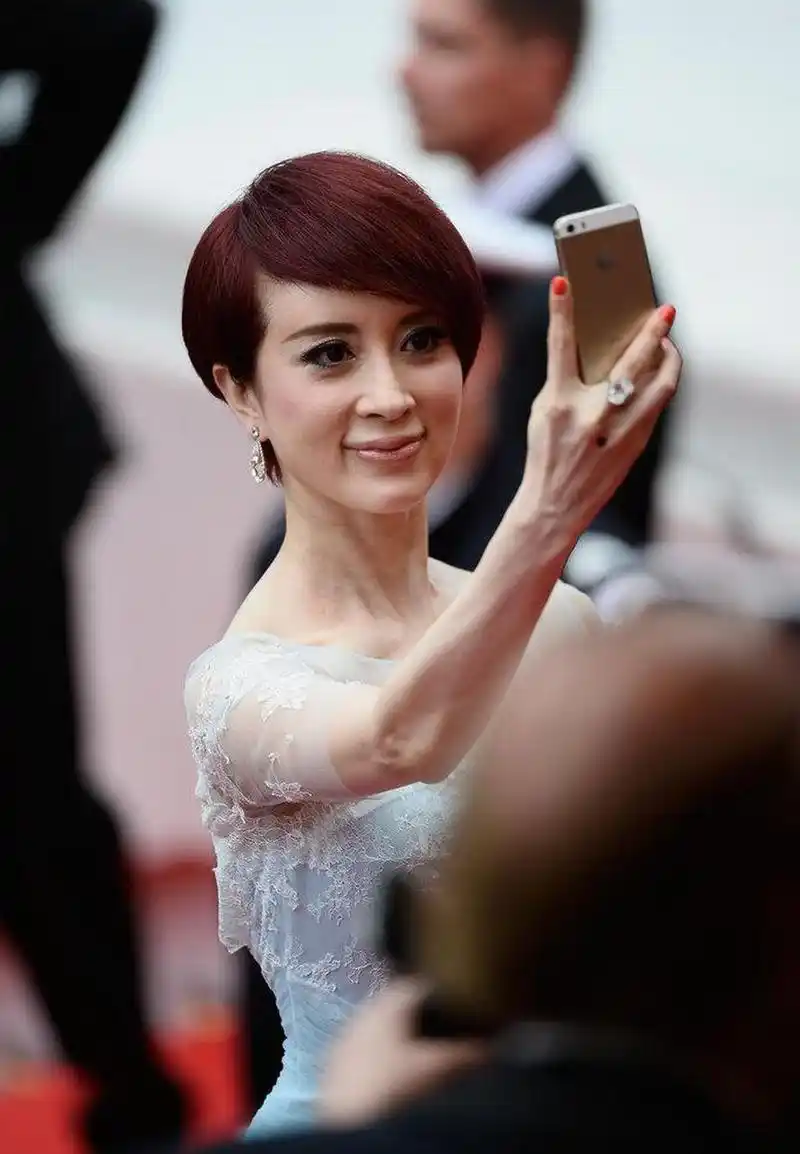 孔雀公主金巧巧,身穿薄纱蓝裙和老公牵手秀恩爱,酒红短发俏皮干练,手