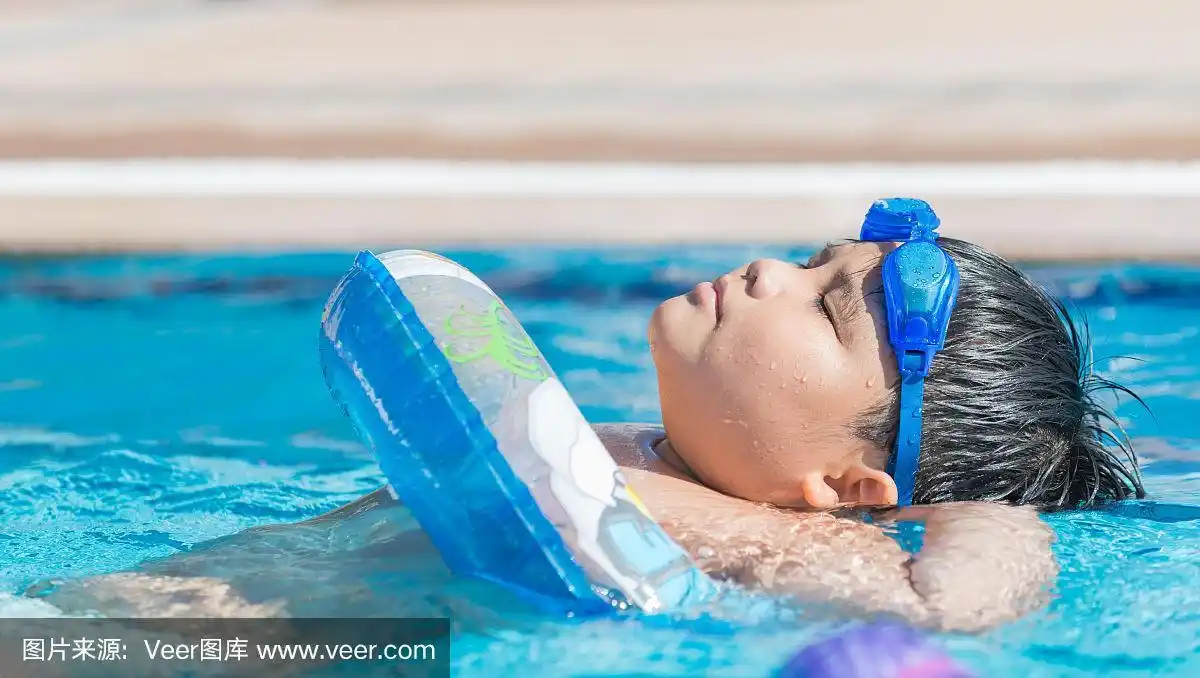 胖男孩睡在游泳池的水面上.