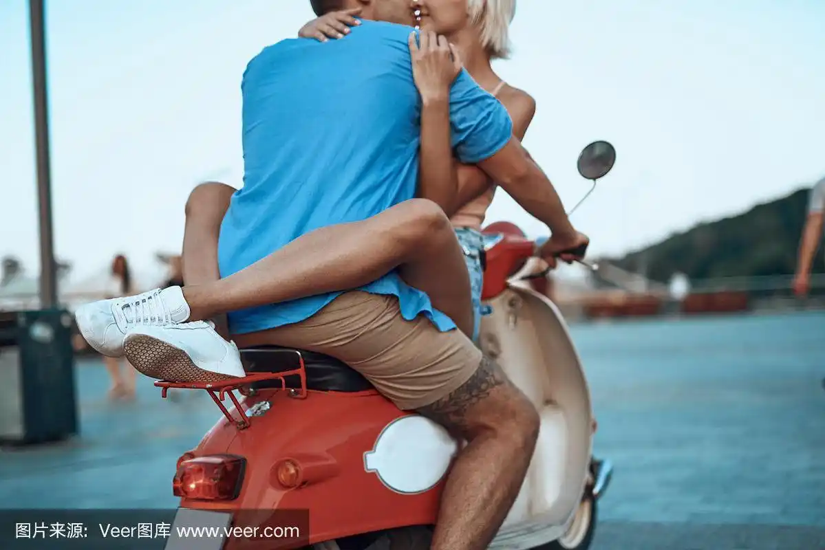 骑摩托车的女人用她的腿拥抱男人的腰