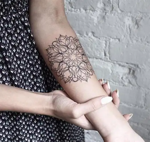 女性手腕外的花朵纹身图案