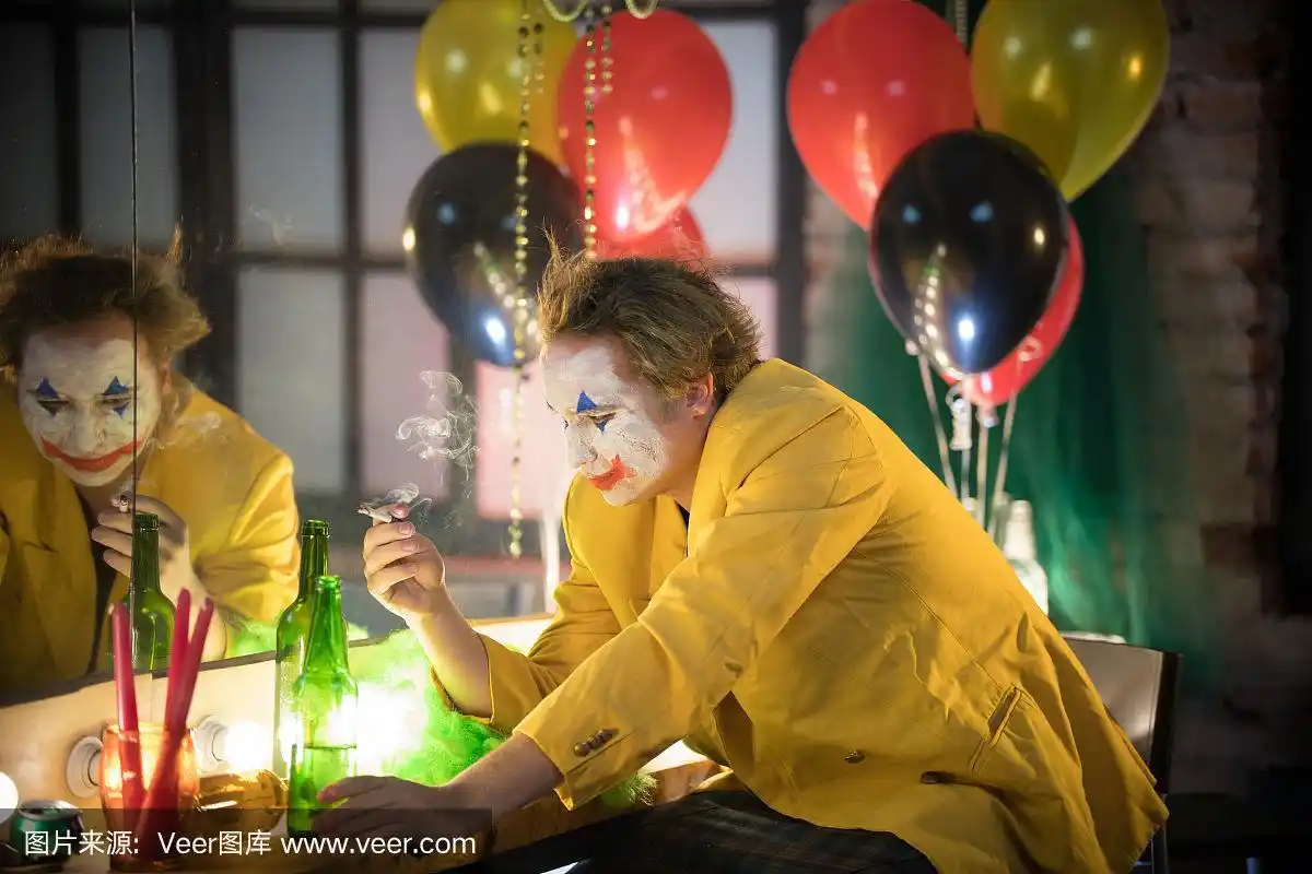 小丑概念——一个穿着黄色夹克的悲伤疲惫的小丑在更衣室里抽烟——他