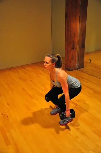 squat by sending your hips back, keeping your back flat, and