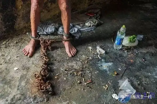 汤坑镇下村一间昏暗破旧的老房子里,一名男子双脚被铁链锁着困在此处