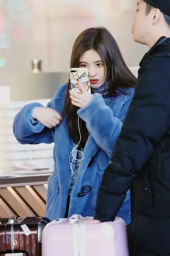 鞠婧祎穿蓝色毛绒外套配黑色长裤现身 拿手机照甩发臭美显俏皮