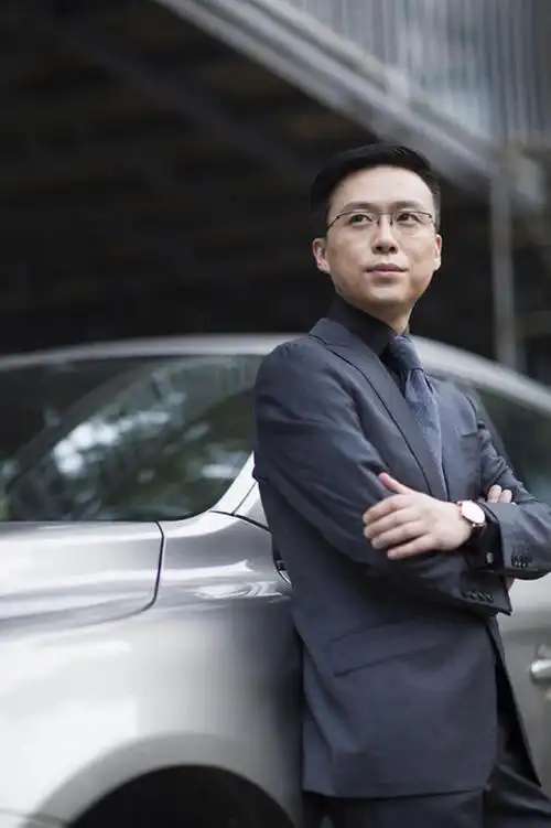 成熟商务男士站在汽车旁