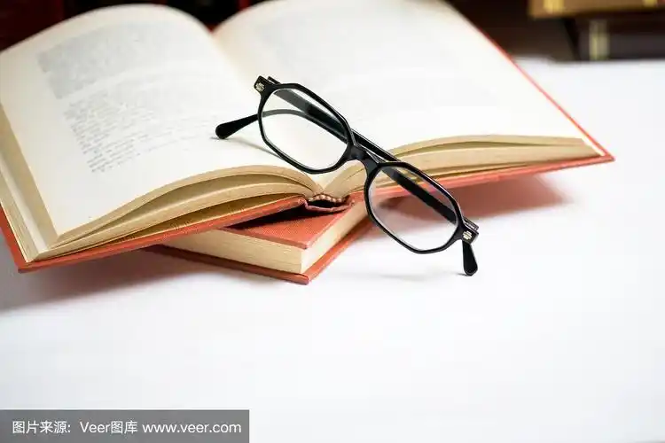 书堆上用眼镜放在图书馆打开的书上.