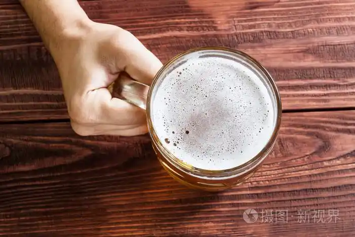 与啤酒杯子的手照片-正版商用图片0damhu-摄图新视界