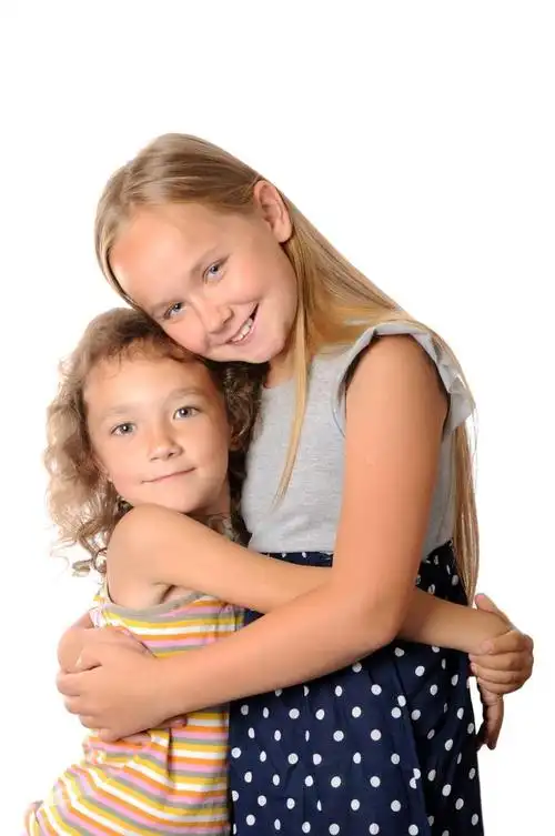 好朋友,两个女孩互相拥抱,在白色背景上