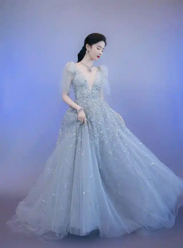 刘亦菲在活动中一袭冰蓝色低v仙女裙,礼服上镶满了各色珠片,在灯光下