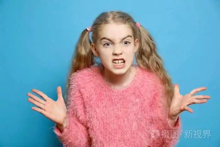 孩子的情绪小女孩气得孤立无援漂亮的小女孩在蓝色背景下生气愤怒的