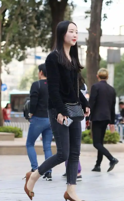 黑毛衣搭紧身牛仔裤脚踩高跟鞋身材娇小气场强大