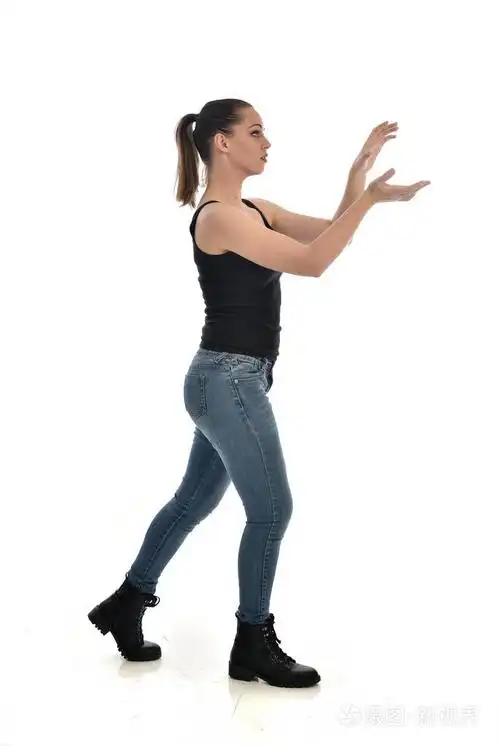 穿黑色单身牛仔裤的黑发女孩的全长肖像. 站立姿势侧轮廓.