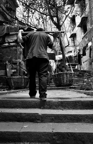 挑蜂窝煤的农民工棒棒,一步一个台阶地往上爬,常年的担子压驼了背,他